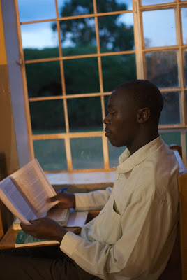 Student reading book by the window