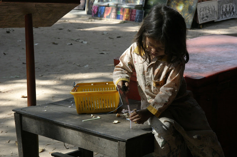 Girl in Angkor Wat selling wares.  She would grab people's attention by making noise with a straw.
