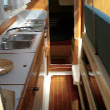 The galley. There is abundant storage under the salon seats to the left. A small cupboard pantry is under the countertop. In the center is the daggerboards, which when raised give the boat a draft of 18" and when down offer over 5' of draft for windward sailing.