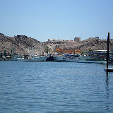 The far side of the bay has concrete docks that are fixed and filled with trawlers.