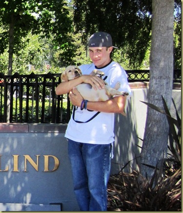 Tyler holds Vienna in his arms in front of the GDB sign.