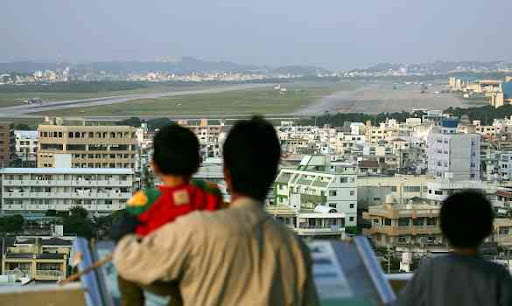 A family in the city of Ginowan looks over the argumentative Futenma airbase