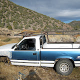 We are suspicious that this car was stolen, given the bullet holes, missing important parts, lack of licenses plates, and its location.  Someone apparently became unhappy with the truck and also stabbed the hood.