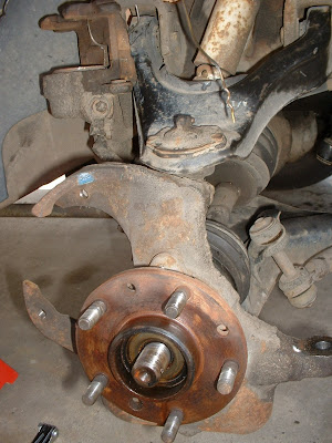 Then I took the brake caliper off and used a delicate and specialized tool called an old coat hanger to tie the caliper up and out of the way.  Then removed the rotor and then the tie rods using the same method as the last post.