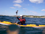 Shawna Franklin paddling a Nigel Dennis Explorer Sea Kayak on Lake Michigan near Duck Lake State Park. Big water droplet on the lens.