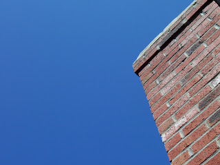 Red brick chimney next to clear blue sky