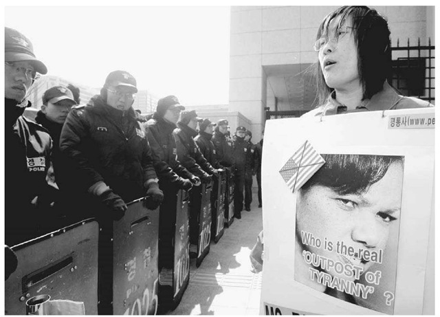 An Anti-American Protestor in Korea. South Korean riot police block a protester holding a poster of U.S. Secretary of State Condoleezza Rice during a rally in Seoul on March 20, 2005. Rice was meeting with South Korean officials to discuss nuclear armament in North Korea. 