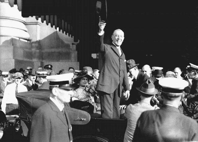 Woodrow Wilson. President Wilson (standing center) waves to a crowd in Saint Louis, Missouri, on September 6, 1919, during a speaking tour to promote the League of Nations.