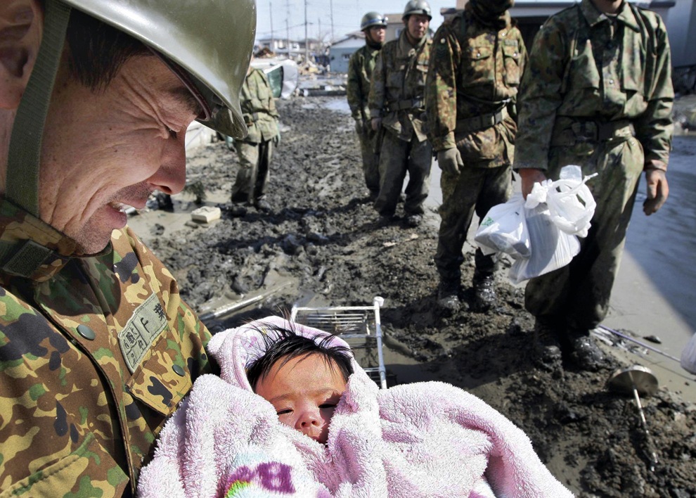 [Un soldado sostiene un bebé de cuatro meses que sobrevivió al tsunami junto con su familia en la ciudad  de Miyagien la prefectura de  Ishinomaki[5].jpg]