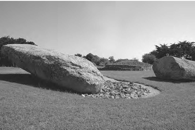 The largest two pieces of Le Grand Menhir Brise viewed from the west, with the dolmen known as La Table des Marchand visible in the distance. 