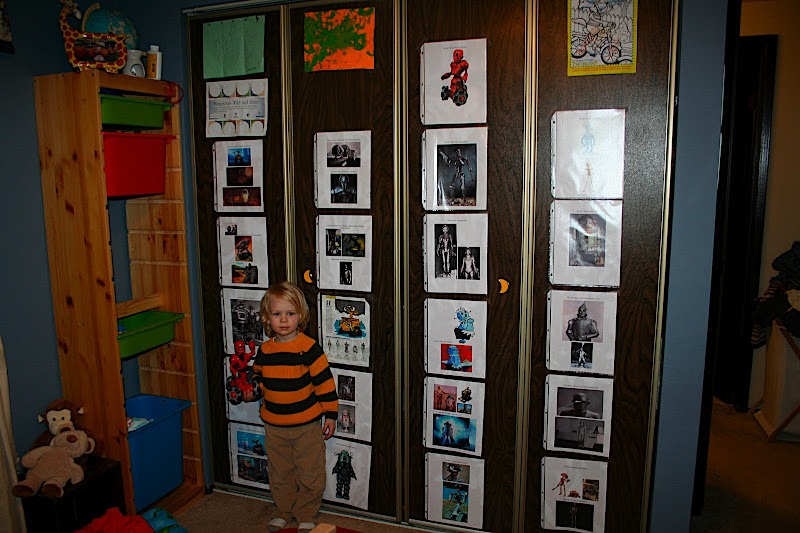 Here is Owen holding his robot, Tribot, and posing in front of all his robot pictures.