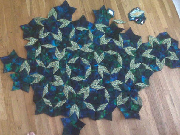 Nucleus of quilt: lozenges of blue and lozenges of gold peacock print are sewn together in an aperiodic tiling.