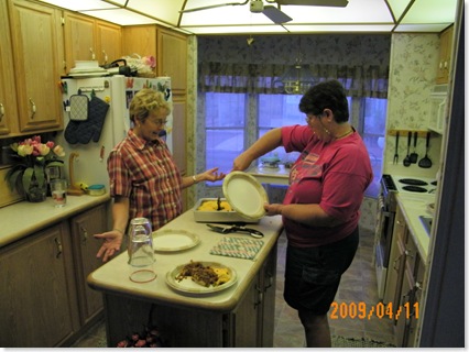 Elaine and Kathy cutting the pan pizza