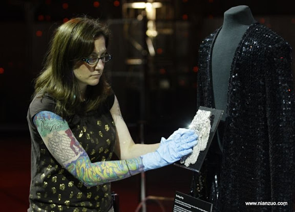 关于杰克逊 Rosa Castaneda, a preparator at the Experience Music Project in Seattle prepares a museum exhibit Friday, June 26, 2009, of a sequined glove and jacket worn by Michael Jackson. A steady stream of fans came to the music museum Friday to view the exhibit and leave written messages on nearby tables. (AP Photo/ Ted S. Warren)