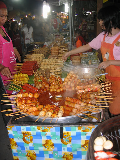 a woman selling food at a street food stall