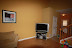 The other end of the living room showing main door, TV, &amp; Powder room door in between