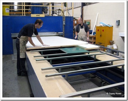 Next large sheets of 40mm polystyrene are placed on the glue. It then goes through the spray booth for another dose of glue before the plastic sheet goes on top. It is then heated and compressed for 15 minutes.