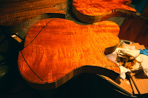 AMX body style (likely to be Prototype 3) rough cut from the slab of figured mahogany. It almost looks like Koa, with a golden honey hue to it. This isn't even properly surfaced or carved. Don't mind those marker lines... they're going as soon as this is run through the planer and drum sander.