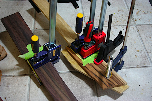 The headstocks attached to the neck blanks of Prototype 1 (rosewood) and Prototype 2 (limba). Prototype 2's neck now has a fillet of zebrawood in the scarf joint between the neck and the headstock. The original glue-up wasn't as clean as it could have been, so i cut the headstock off and started again. As a result, i lost a fraction of an inch in overall length, so the options were to either have the fretboard overhang slightly, or add a fillet to push the headstock back. So it was to fix a mistake, but it'll add a cool crescent-shaped accent to an otherwise plain neck. (... and this is why they're prototypes!)