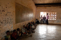 Acrobatics Show at the School House This room is typical for a school house run by the Malawian government. The younger children have gathered here on a Saturday to see the older boys by the window perform acrobatics and staged Tae Kwon Do fights.
