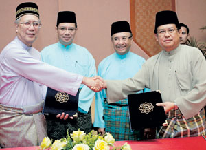 Saifuddin Abdullah (dua dari kiri) dan Dr. Awang Abdul Rahman Mohammad Taib menyaksikan Dr. Syed Arabi Aidid (kiri) bertukar-tukar dokumen dengan Dr. Yusop Awang Damit (kanan) pada majlis MoU antara UIAM dengan UNISSA, semalam.