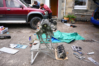 New head with manifolds on bench, old head on ground