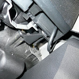 Underneath the glovebox - the cable exits from the glovebox hinge and snakes into the center column. It is invisible from the passenger's view.