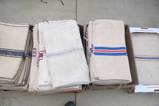 French flour sacks are piled inside one dealer's tent. These can easily be turned into pillows.
