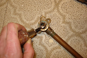 After gingerly weakening the metal in a few spots with the hacksaw, I pried it out with needlenose pliers and screwdriver