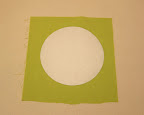 Iron one freezer paper circle onto the wrong side of a piece of fabric, shiny side down.