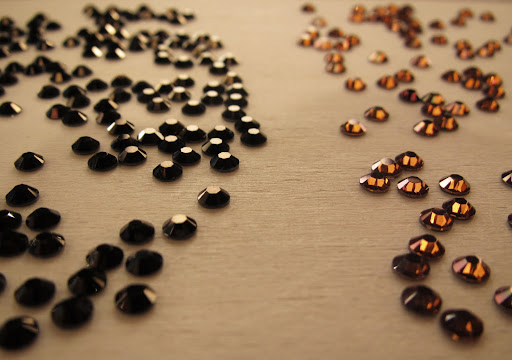 lay rhinestone on a work surface, glue side face down