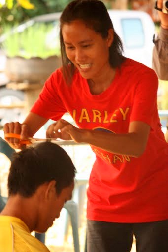 Prayoon's sister begins the ceremon of cutting his hair Prayoon