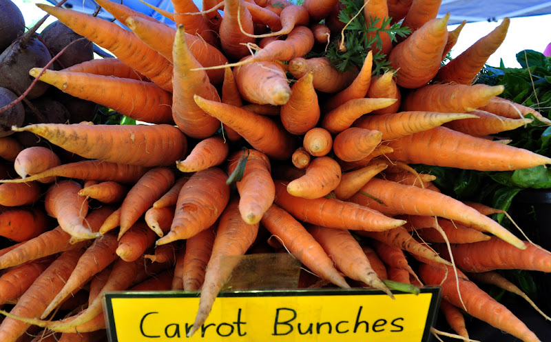 7/11/2010-Carrots grown in Mareeba point out at customers.