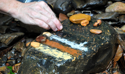 Adrian Hall, Daintree Discovery Tours guide, rubs ochre, which aboriginals use for paint, on a rock. After he painted the arm of one of the tour patrons.