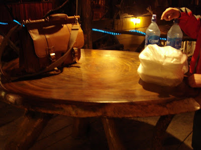 OK, its too bad this photo came out so terribly, but I had to include it so you could get a sense of scale.  This table is a slice of one tree -- you can see the rings.  The bag that I put on the table is 17 inches across, and the bottles of water aren't the small ones -- they're 2 liter bottles.  That's a big tree.