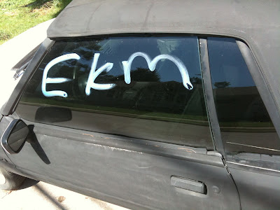 The Graffiti On This Car At The Intersection of East Van Buren Street And South Iowa Avenue In Washington Says "EKM", Despite The Washington County Public Safety Center's Report Of "JKM" Graffiti.