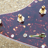 Front of the pickguard with pots and switch attached.
