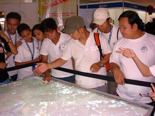 Students try navigating the huge Google Earth touch screen pad.
