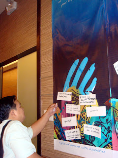 Sir Ervin posts his message on the Rights of Disabled Persons wall.