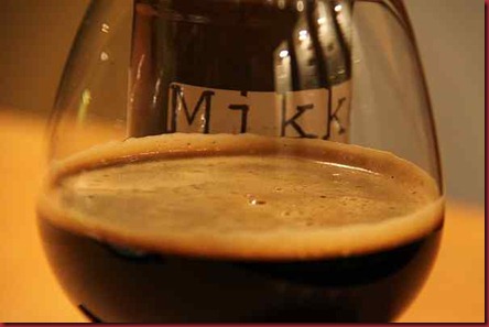 Mikkeller_BlackTie_g&b_bottlebehindglass Mikkeller_BlackTie_g&b_bottlebehindglass
