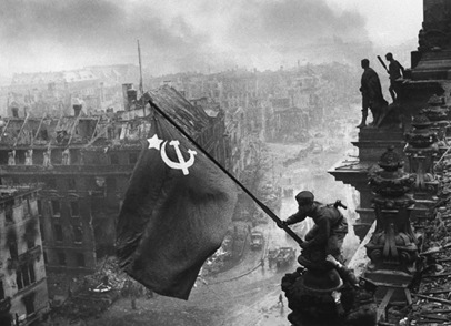 Yevgeny Khaldei - Soldados do Exército Vermelho levantam a bandeira da União Soviética sobre o estandarte dos nazistas em Berlim em 1945