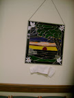 A stained glass picture created by Nancy Czejkowski and her husband was given to St. Andrew's in honor of vicar Roland Sherwood. A new plaque for the picture is about to be unveiled.
