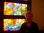 JoAnn Hodgson with the stained glass window commemorating the Miracle of the "Loaves and Fishes"