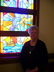 JoAnn Hodgson with the stained glass window commemorating the Miracle of the "Loaves and Fishes".