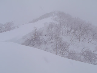 P1253 付近の尾根屈曲点では大きな雪庇が東側に張り出している。雪庇の下は急峻な谷の源頭だ。