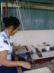 A villager demonstrates weaving