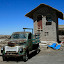 An especially junked up van in front of a church made of salt.