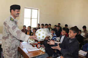 Local school children receive soccer balls and t-shirts from the Iraqi Department of Border Enforcement’s Lt. Col. Abdul Hasan, during a brief stop at one of two local schools in southern Maysan Province. “The smiles of the children make me look forward to future visits and offering gifts,” Hasan said.