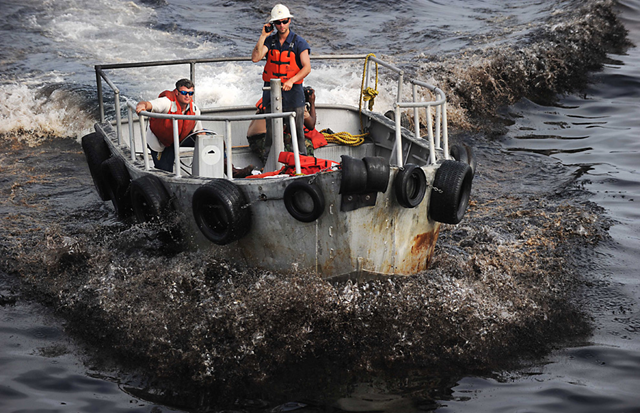 Bruce Padilla, left, and Adam Shaw, Louisiana oilfield divers, return through blackened seawater from watching a controlled oil burn in the Gulf of Mexico May 7, 2010. (U.S. Navy photo by Mass Communication Specialist 2nd Class Justin Stumberg / Released)