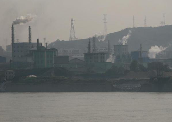 Factories line the shores of the lower Yangtze River in China. Heavy pollution tied to China's rapid industrial growth has produced poor visibility and health effects. (Credit: Copyright UCAR, Photo by William Bradford)
